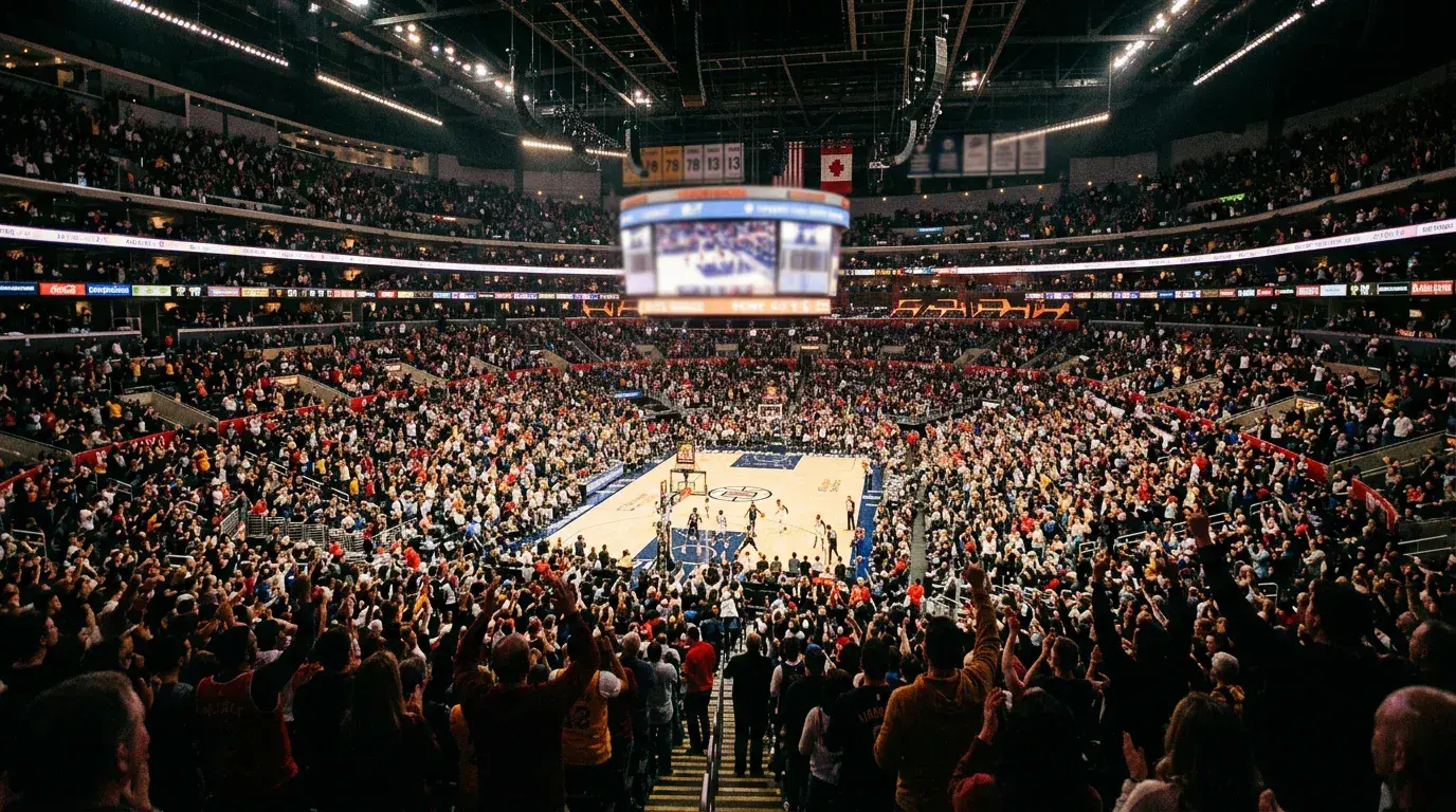 Packed NBA arena with fans cheering during a close game under bright court lights